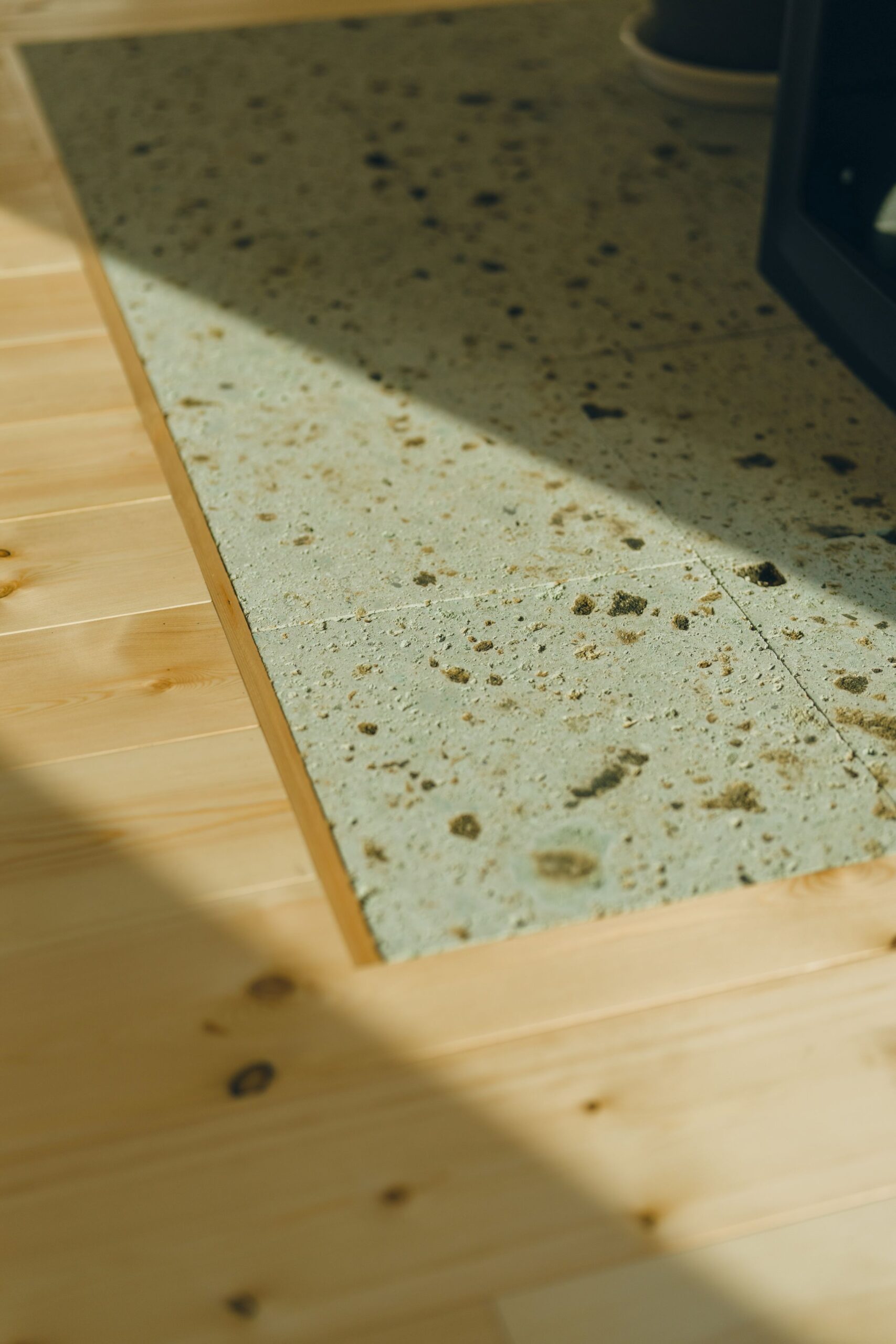 薪ストーブのまわりには耐火性能の高い大谷石を敷きに